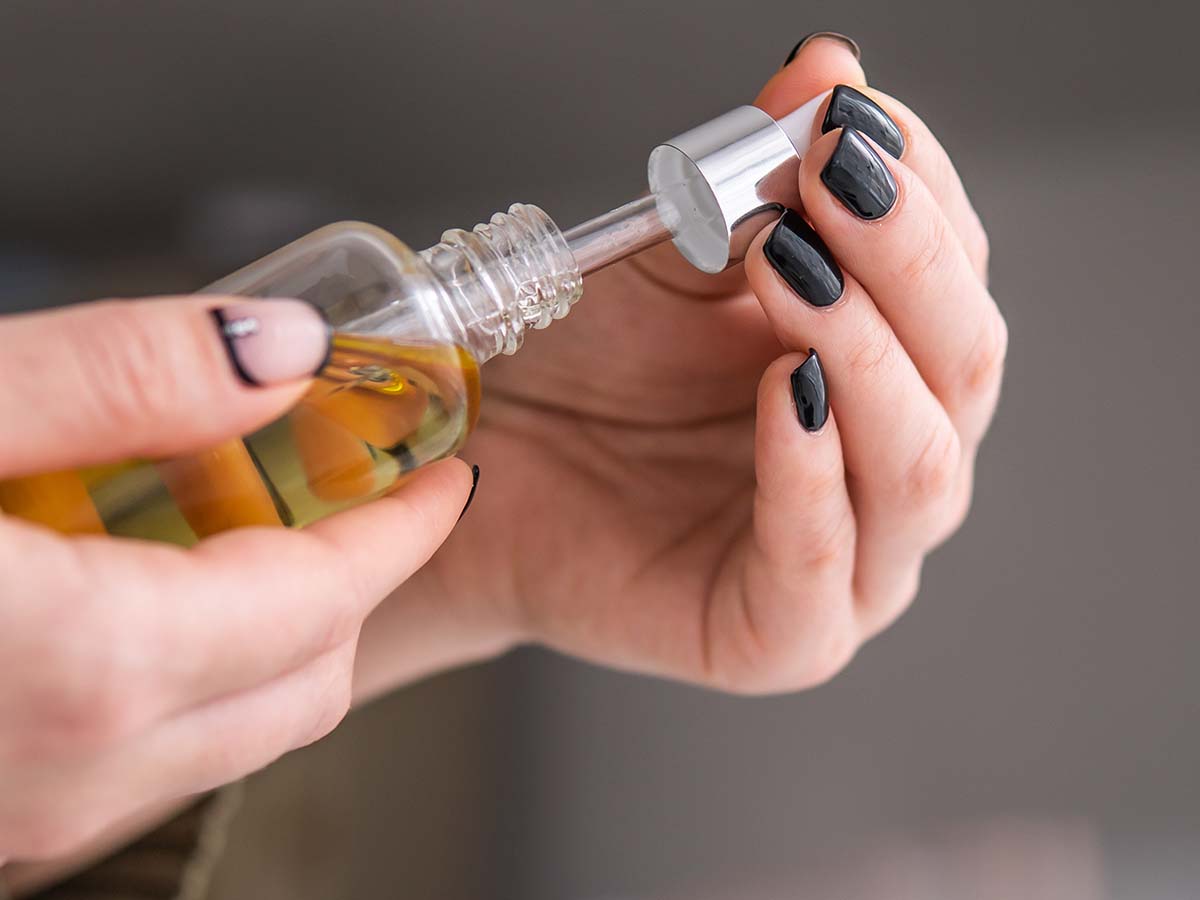 hands opening CBD bottle
